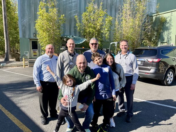 Make a Wish kid Ross poses with his family and Disney Imagineers