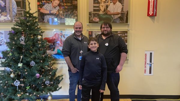 Make a Wish kid Ross poses with Walt Disney Imagineers